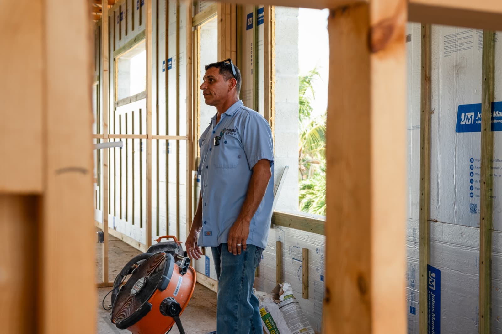 Contractor standing in front of a framed house in Tampa Bay