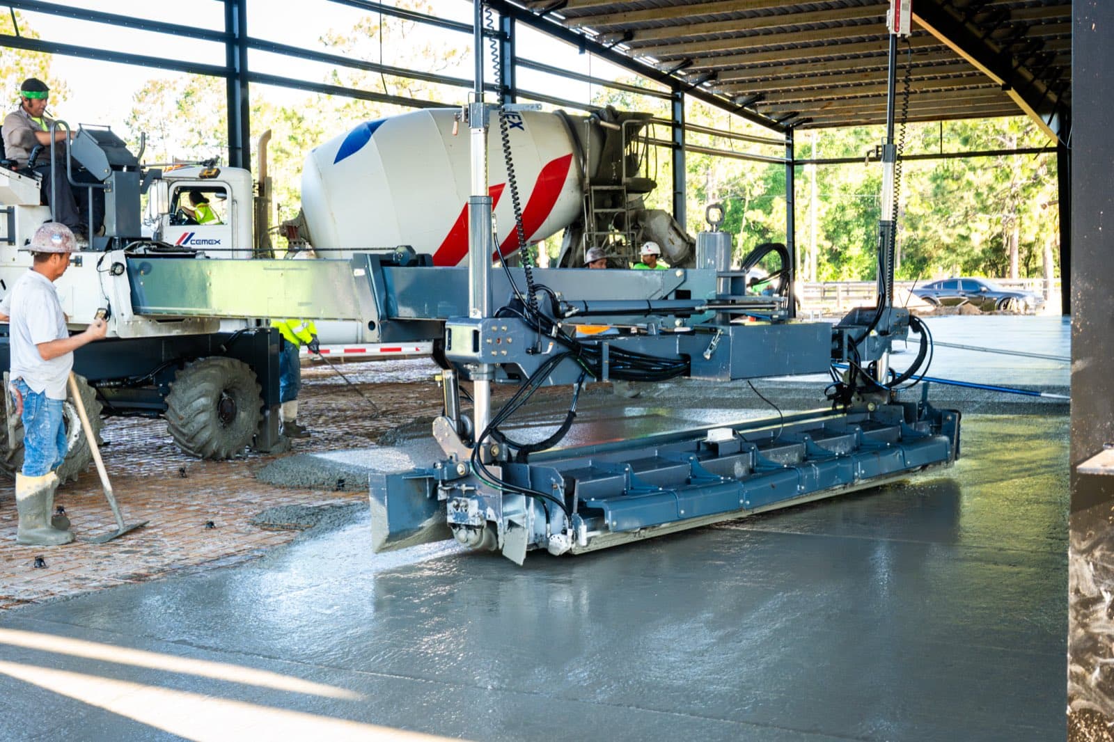 Crew running a laser screed across a fresh concrete slab on a Tampa Bay job site