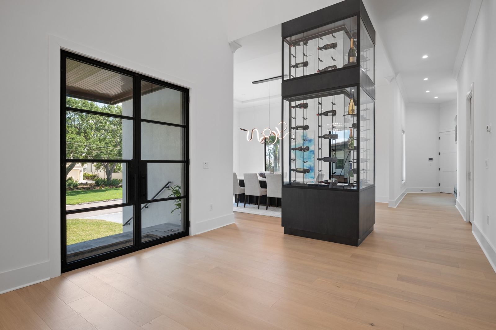 Entry with steel-framed glass doors and a glass wine tower